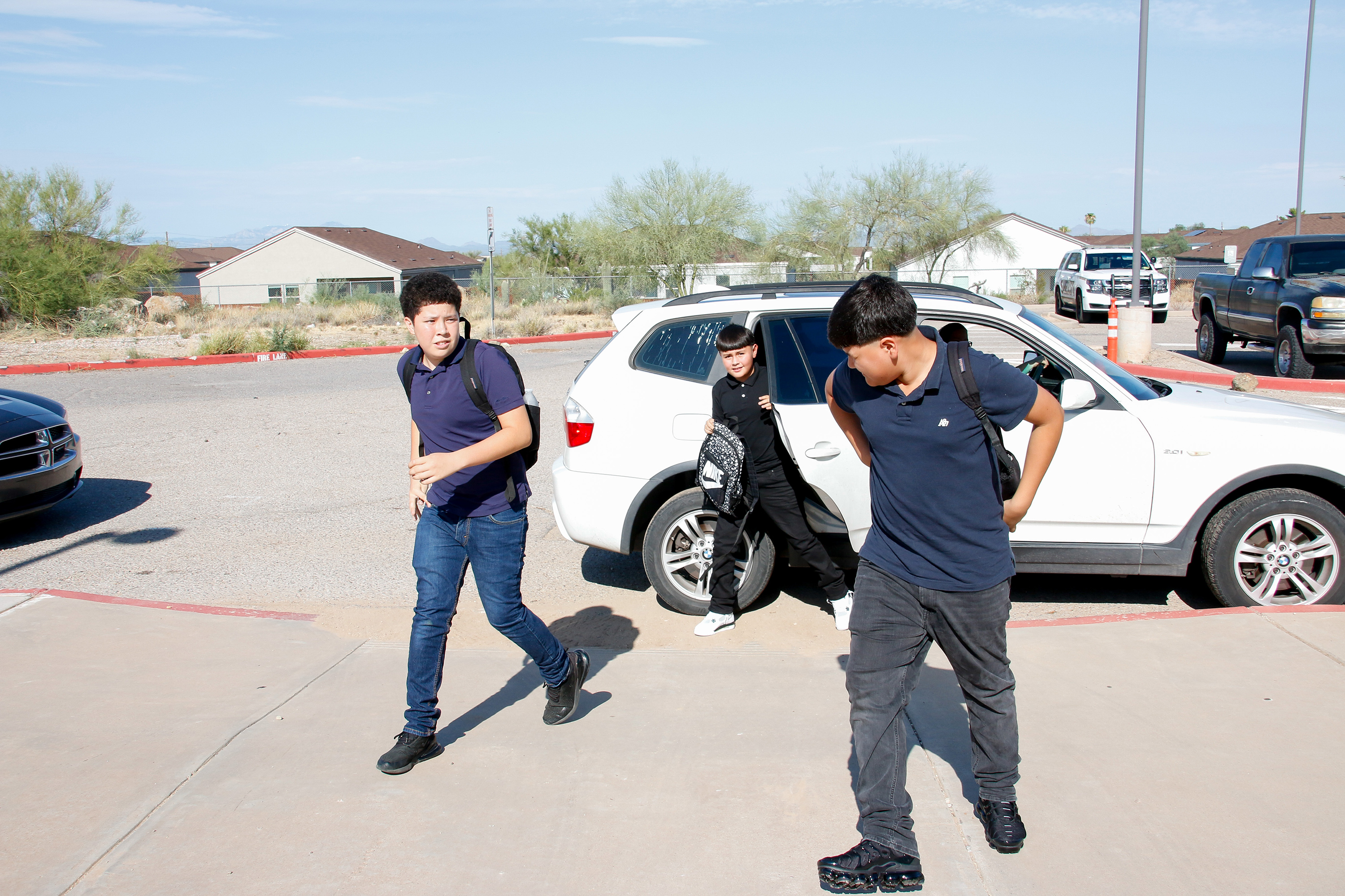 Three boys get out of the car and head into school on the first day